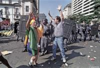 Elderly man and Police calm stone-throwing protesters near the Bourse in Rio.