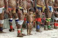 A child amid adults of the Kuikuro indigenous people.