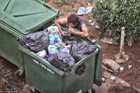 Homeless man scavenges a meal from a garbage dumpster in the capital.