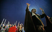 Worshipers pray in the rain before sunrise at the Valley of the Dawn.