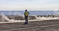 A catapult officer launching fighter aircraft aboard the USS Nimitz.