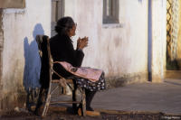 An elderly woman relaxes outside her home as the sun sets in Artigas, Uruguay.
