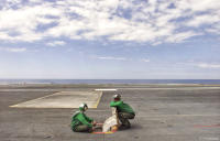 Navy crewmen during a lull in flight operations aboard the USS Enterprise.