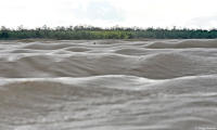 Stranded surfer awaits rescue in the turbulent aftermath of the Pororoca.