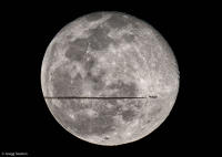 Southbound jet streaks past a full moon and Tycho crater.