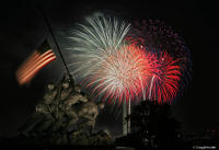 Independence day fireworks explode above the Marine Corps War Memorial.